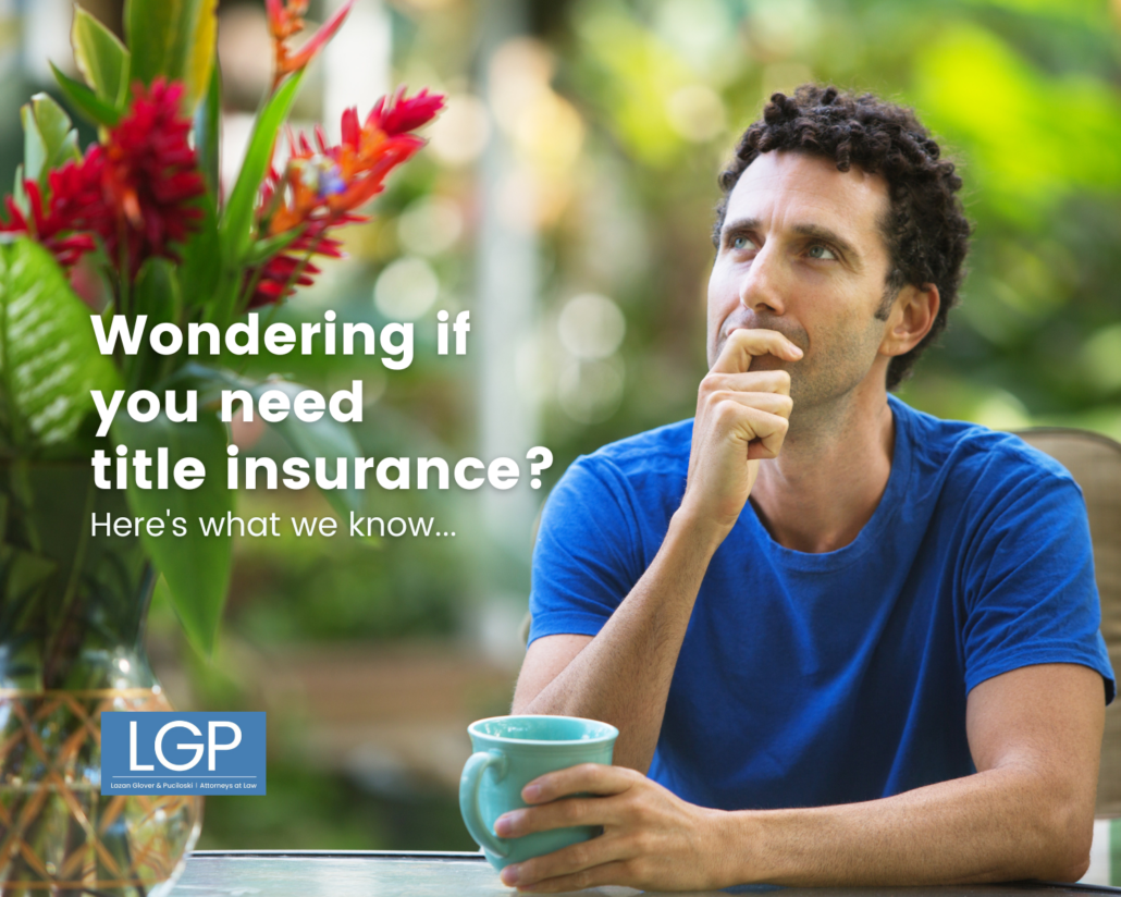Thoughtful man in blue shirt with blue coffee cup wondering if he needs title insurance